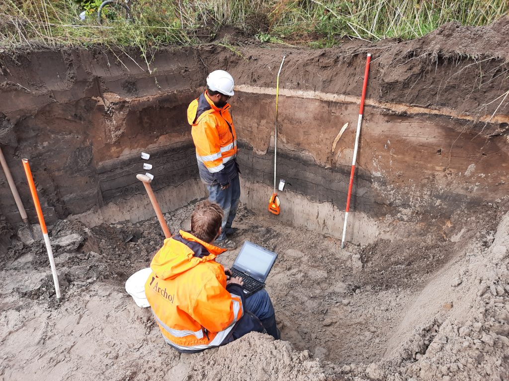 Bij archeologisch onderzoek wordt een profiel in het duingebied gedocumenteerd.